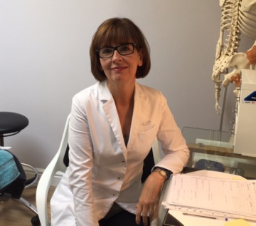 Stella Archer at her desk in her clinic